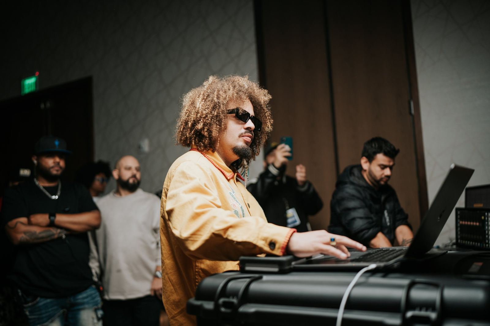 A producer working on a laptop while attendees watch