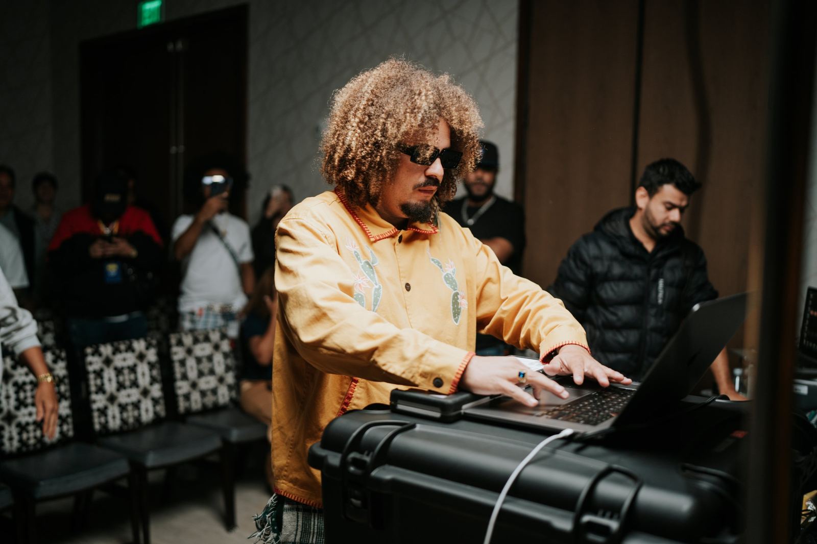 A producer building a track on a laptop in front of attendees