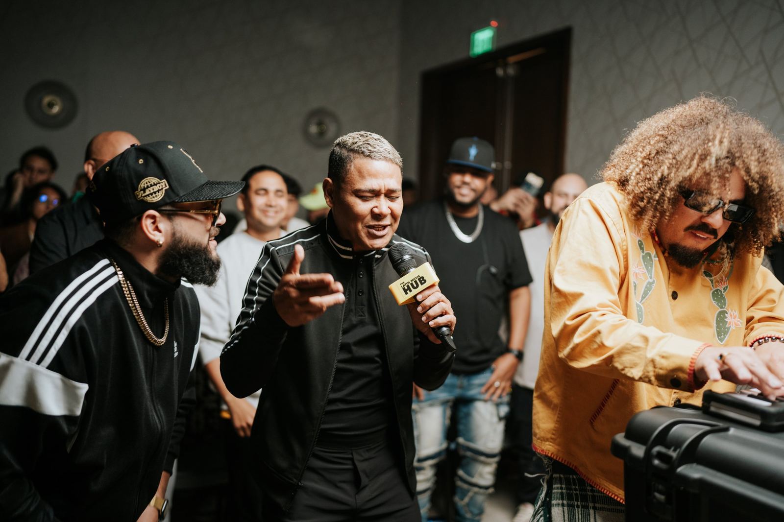 Artists singing over a beat during a live session as attendees look on